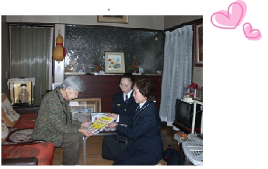 1人暮らしの高齢者宅を訪問する女性消防団の画像