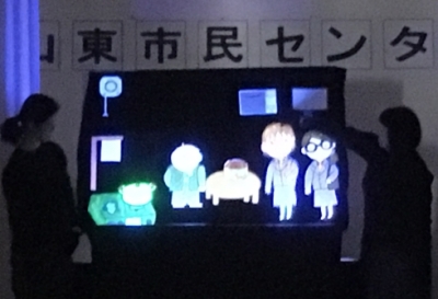 パネルシアター画像1：部屋を暗くし、光る人形で劇をしています。