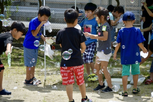 レッツトライの夏のお楽しみ会で、たくさんの子どもたちがシャボン玉遊びをしている写真