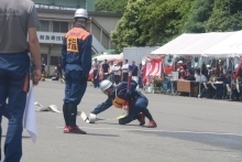 消防団員がホースを延ばしている写真